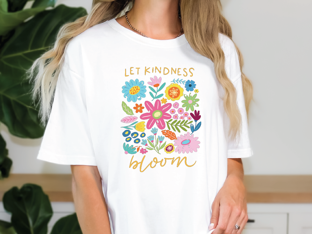 a woman wearing a t - shirt that says let kindness bloom