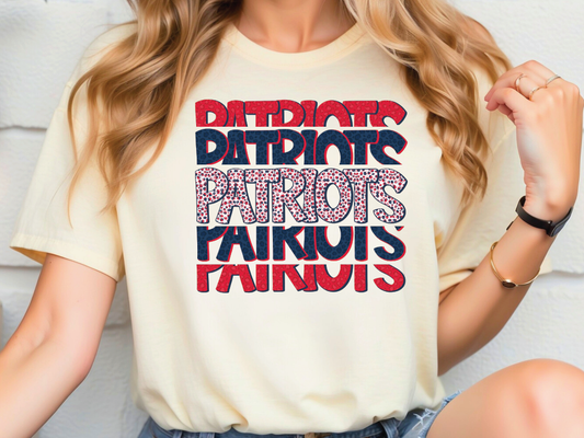A person wearing a white t-shirt with the text "Patriots" printed on it.