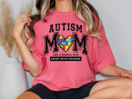 a woman wearing a pink autism mom t - shirt