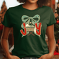 A woman wearing a green t-shirt with a graphic design of a Christmas nativity scene and the text "Joy" printed on it.