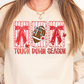 A woman wearing a white sweatshirt with a graphic design featuring a football, red bows, and the text "TOUGH DOWN SEASON".