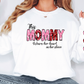 a woman wearing a white shirt with the words mommy written on it