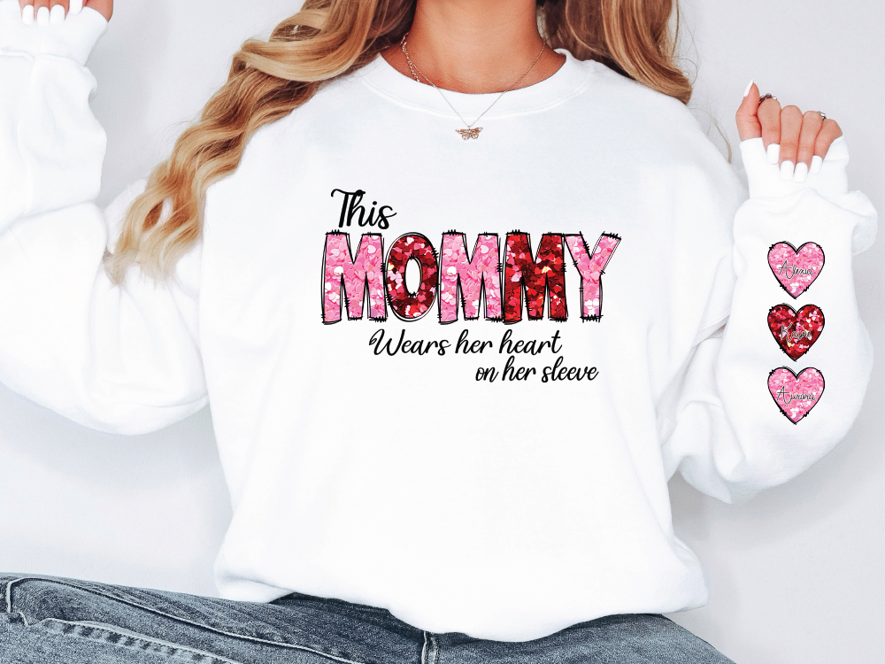 a woman wearing a white shirt with the words mommy written on it