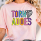 A woman wearing a pink t-shirt with the text "TORNADO ADOES" printed on it.