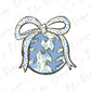 A blue and white polka dot bow is tied around a Christmas ornament with a floral pattern.