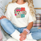 a blonde woman sitting on a bed wearing a t - shirt with a dog on