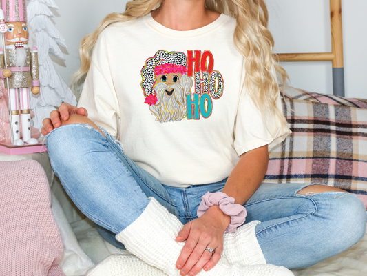 a blonde woman sitting on a bed wearing a t - shirt with a dog on