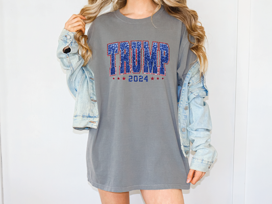a woman wearing a gray shirt dress with the word trump printed on it