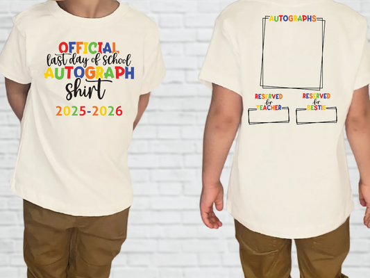 a white t-shirt with a colorful design and text printed on it. The design includes the text "Official last day of school autograph shirt" and "2025-2026", suggesting it is a commemorative item for the last day of school in the year 2026.