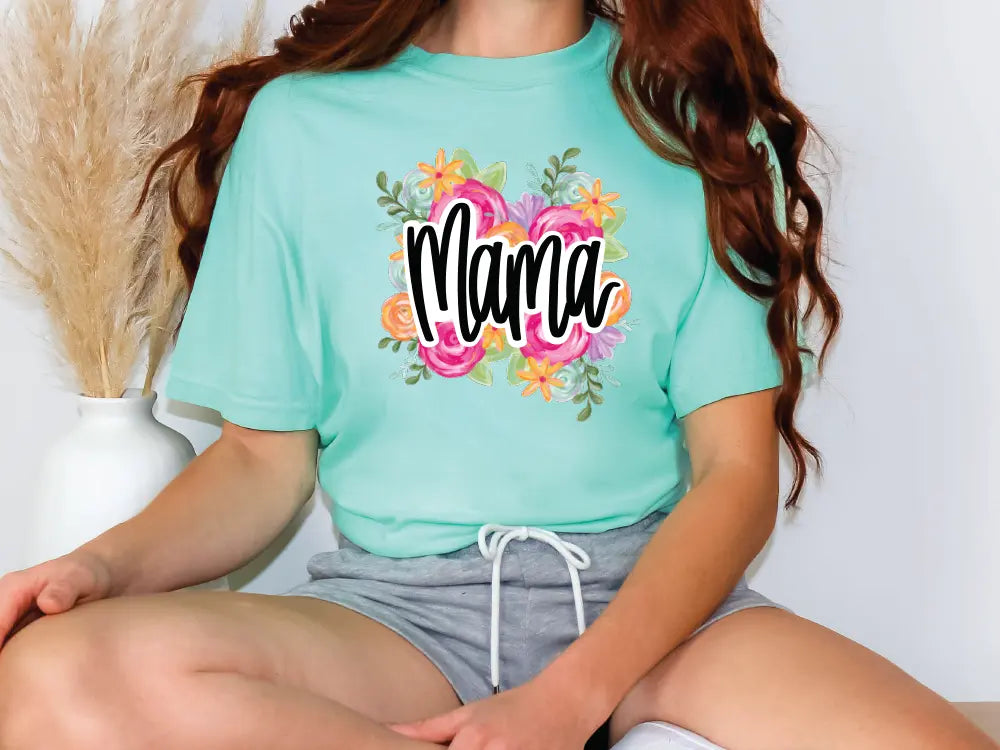 a woman sitting on a stool wearing a t - shirt that says mama