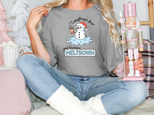 a woman sitting on a bed holding a snowman t - shirt