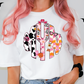 A person with pink hair wearing a white t-shirt with a colorful monogram design.
