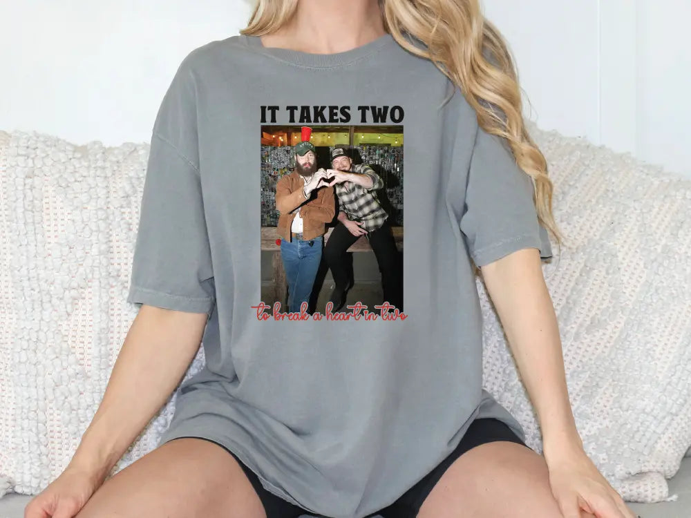 a woman sitting on a couch wearing a t - shirt that says it takes two