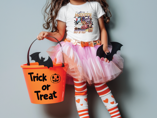 a little girl in a halloween costume holding a trick or treat bucket