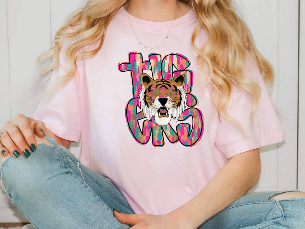 a woman wearing a pink shirt with a tiger on it