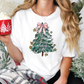 a woman holding a cup of hot chocolate in front of a christmas tree