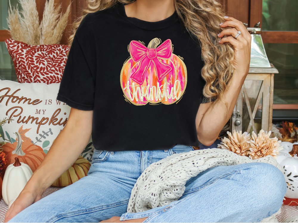 a woman sitting on a couch wearing a black shirt with a pink bow