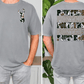 a man wearing a gray t-shirt with a camouflage pattern and the text "POINTERS POINTERS POINTERS" printed on the back.