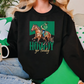 a woman sitting on a couch wearing a black sweatshirt with a picture of a horse