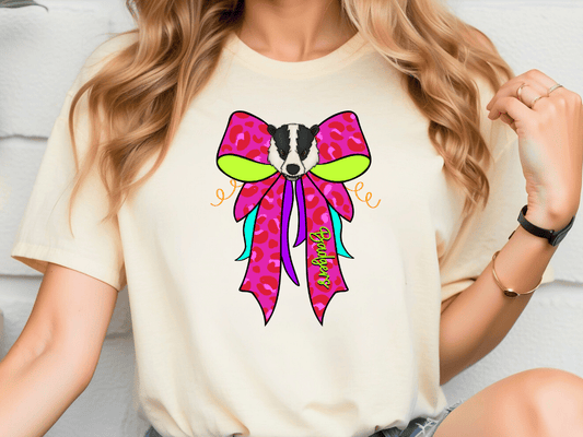 A woman wearing a white t-shirt with a colorful bow graphic on it.