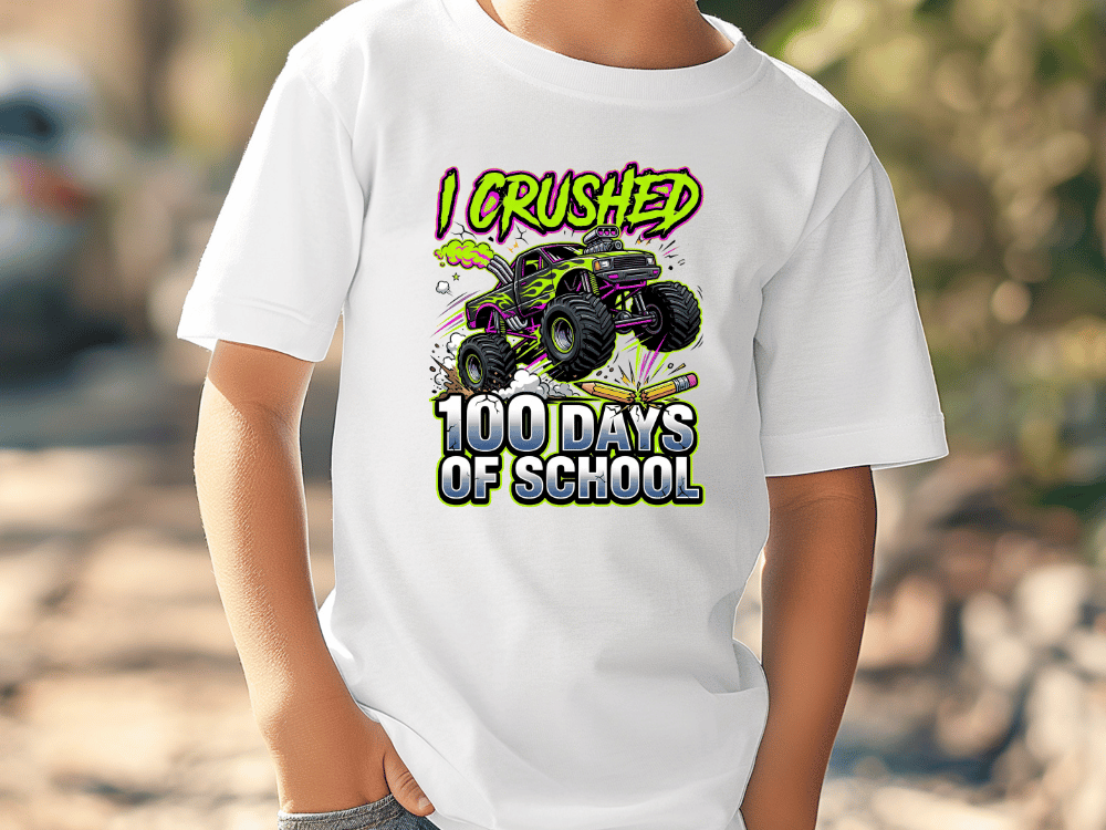 A white t-shirt with a graphic design depicting a monster truck and the text "I CRUSHED 100 DAYS OF SCHOOL".