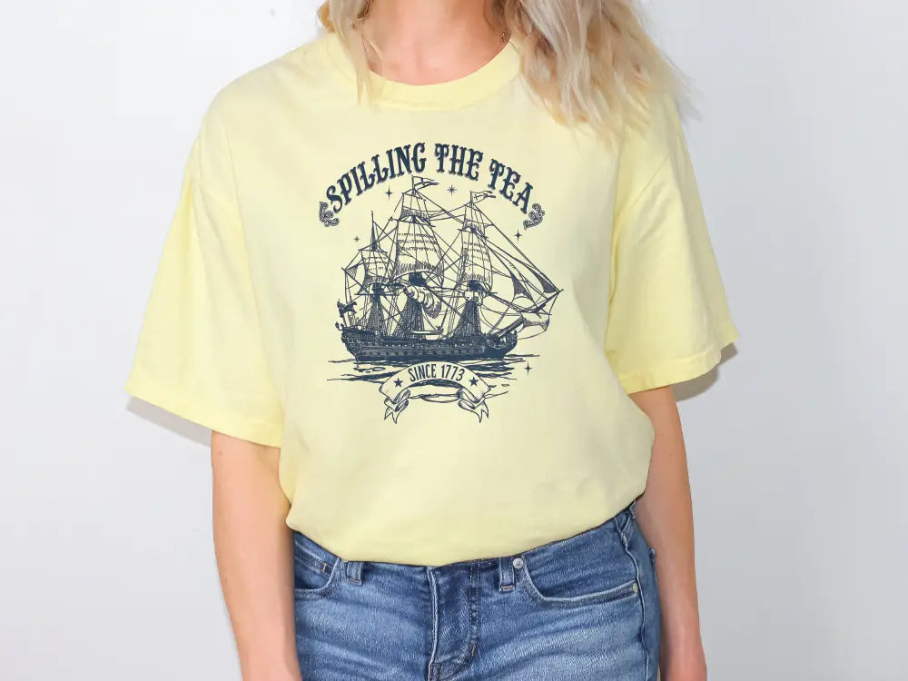 a woman wearing a yellow shirt with a sailing ship on it