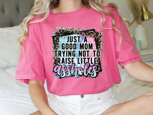 a woman sitting on a bed wearing a pink shirt