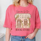 a woman wearing a pink shirt that says take me to the book store