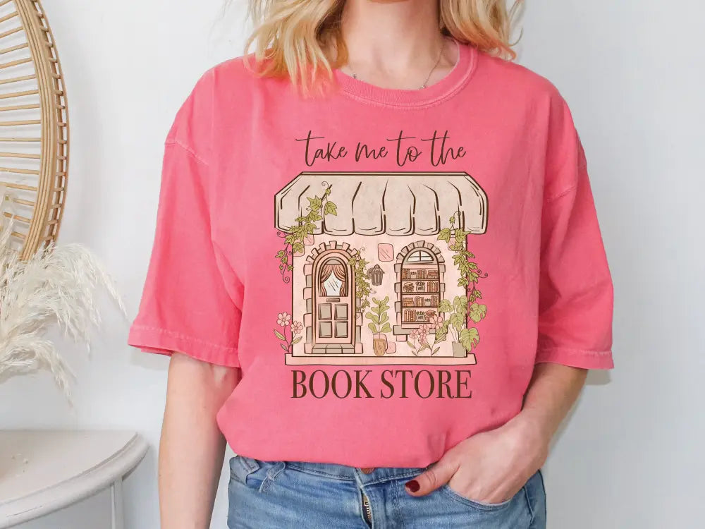 a woman wearing a pink shirt that says take me to the book store