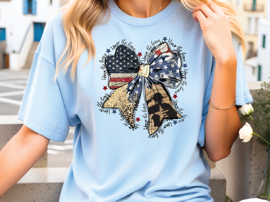 a woman wearing a blue shirt with a patriotic bow on it