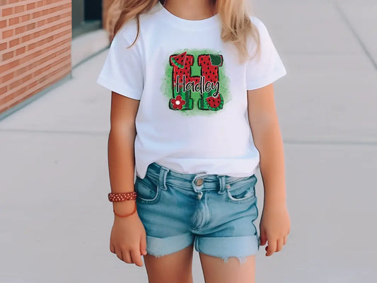 a little girl standing on a sidewalk wearing a white shirt