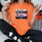 a woman sitting on a bed wearing a halloween shirt