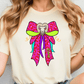 A woman wearing a white t-shirt with a colorful graphic design of a bow with a sheep's head on it.