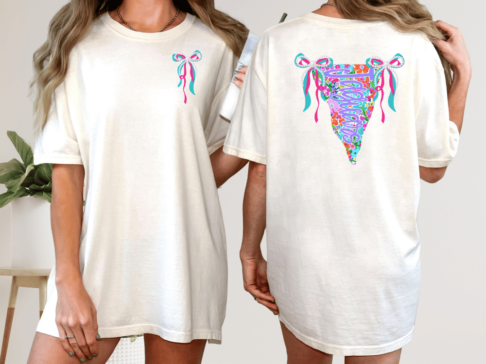 two women wearing white t-shirts with colorful, abstract designs on the back.