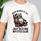 a man wearing a white shirt with a raccoon on it