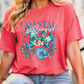 A woman wearing a red t-shirt with a colorful graphic design of a horse and tropical leaves.