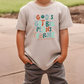 a young boy standing on a sidewalk wearing a t - shirt that says go '