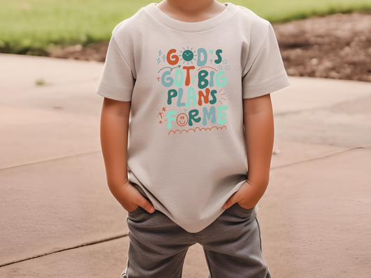 a young boy standing on a sidewalk wearing a t - shirt that says go '