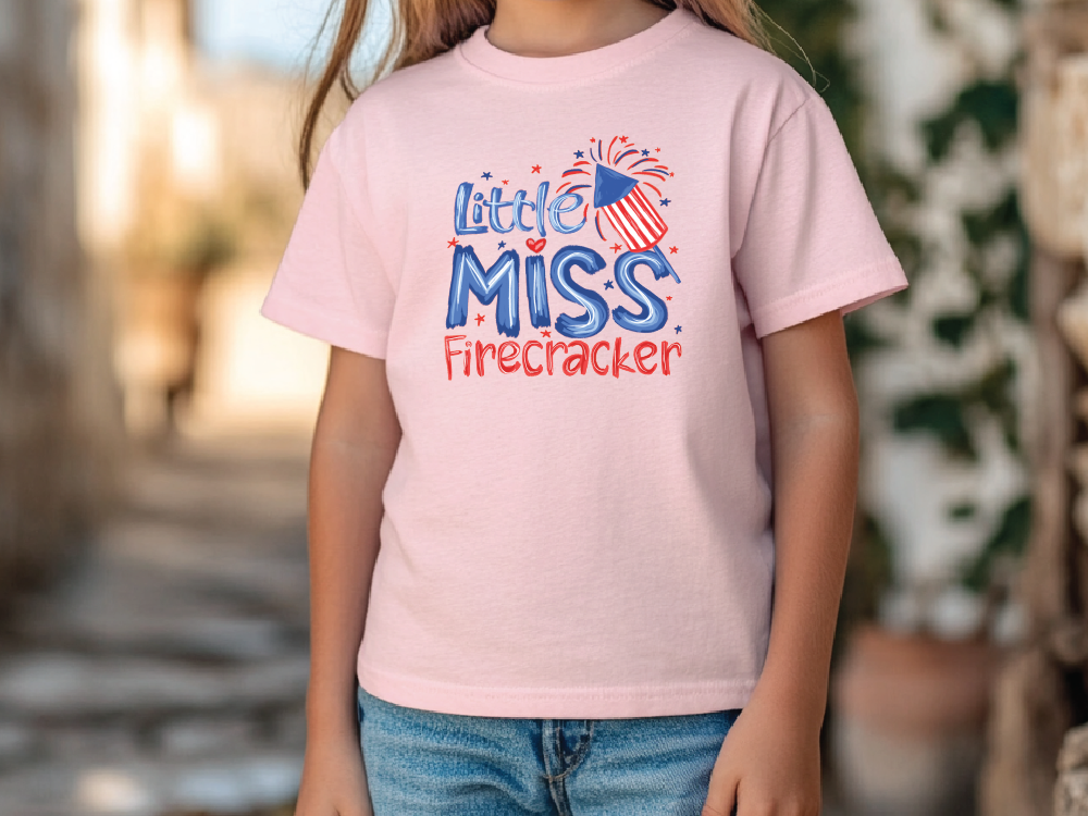 a little girl wearing a pink shirt that says little miss firecracker