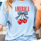 a woman wearing a blue shirt with two cherries on it