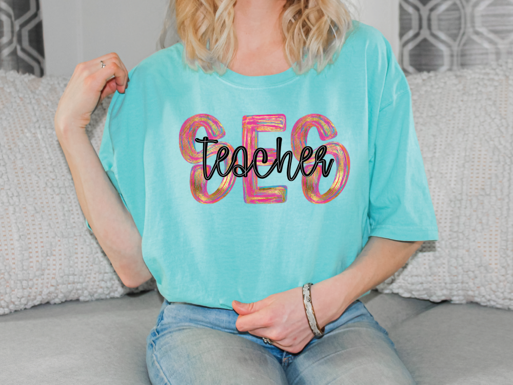 a woman sitting on a couch wearing a teacher shirt