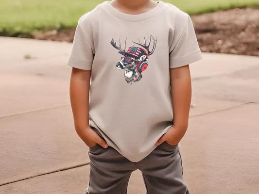 a young boy wearing a t - shirt with a deer head on it