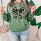 a woman wearing a green hoodie with a leopard print bow on it