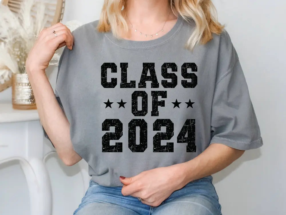 a woman sitting on a chair wearing a t - shirt that says class of 202