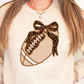 A woman wearing a white sweatshirt with a leopard print design and a football on it.