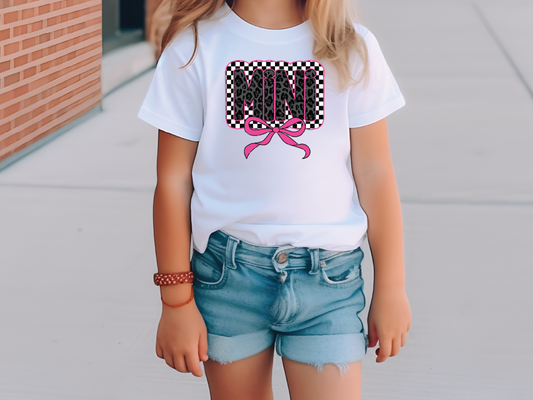 a little girl wearing a white shirt and jean shorts