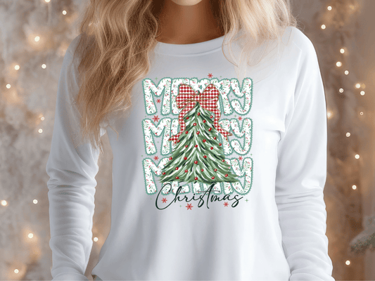 A woman wearing a white long-sleeved shirt with a Christmas tree design and text printed on it.