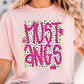 A woman wearing a pink t-shirt with the text "MUSTangs" printed on it.