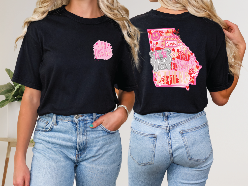 two women wearing black tshirts with pink and white designs on them