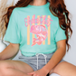 A person wearing a turquoise t-shirt with a fish graphic and the text "Shake that" printed on it.